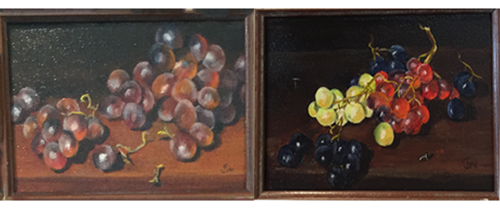 Two paintings of grapes on a wooden table.