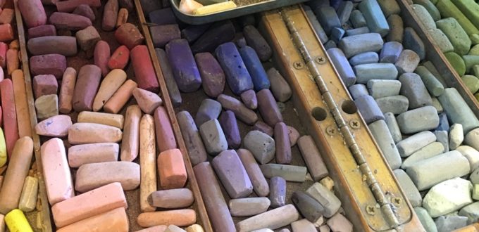 A vibrant pile of colored chalks on a table, inspired by The Guild of Harwich Artists.