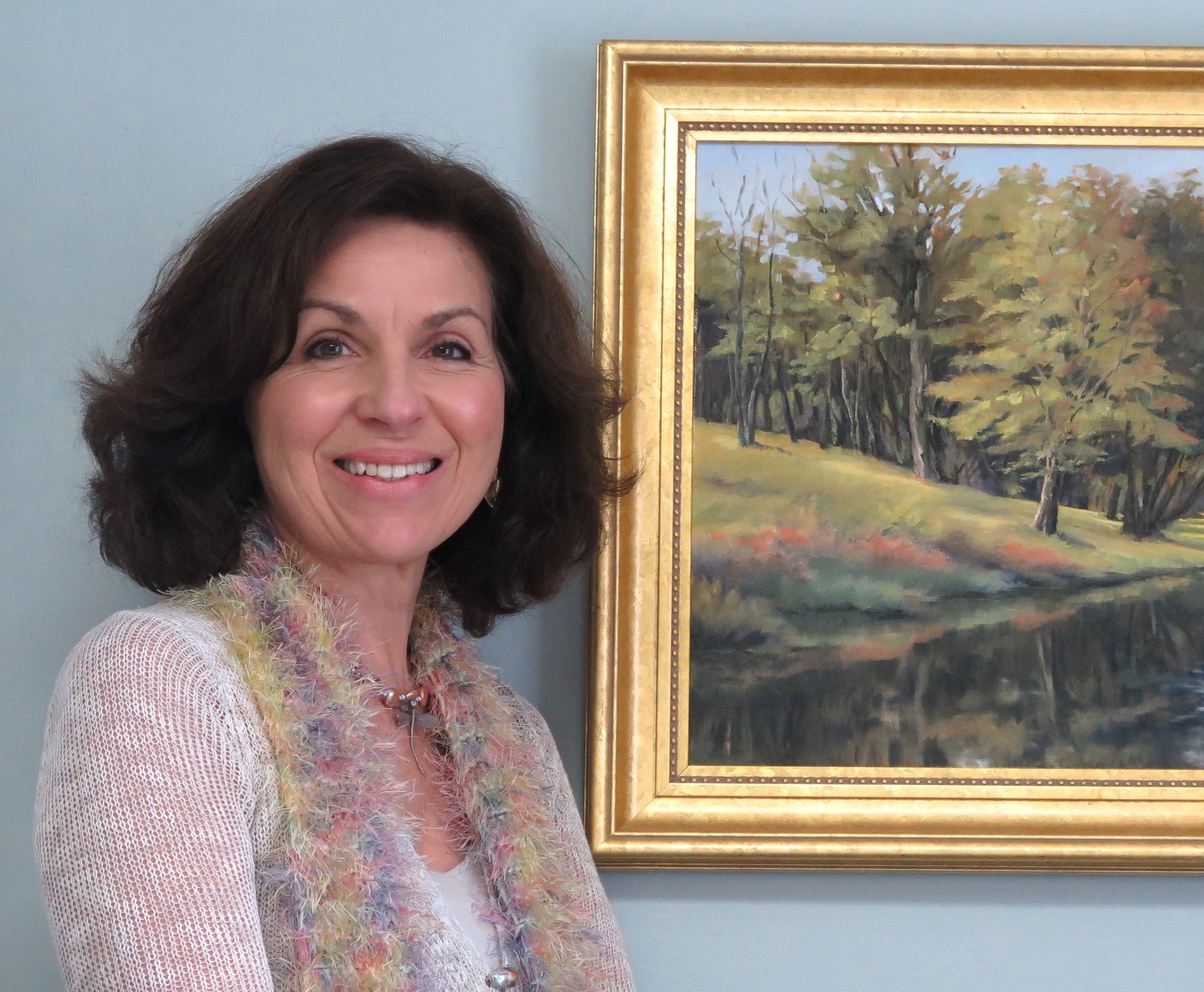 A woman standing in front of a painting.