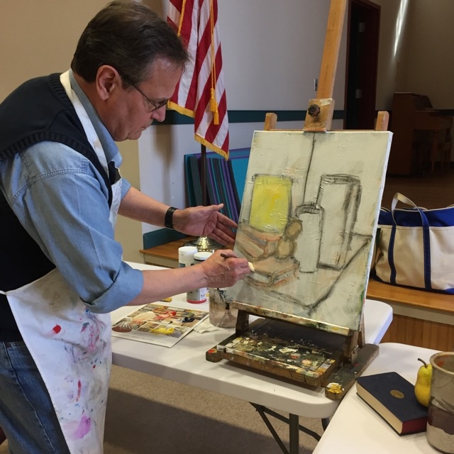 A member of the Guild of Harwich Artists painting on an easel.