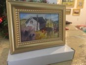 A gold frame with a watercolor painting on it.