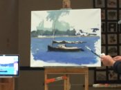 A man painting a boat on a easel.