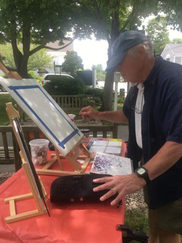 A man painting on a easel.