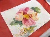 A watercolor painting of a flower on a table.