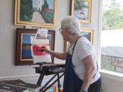 A woman painting on a easel.