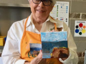A woman showing her painting and the picture