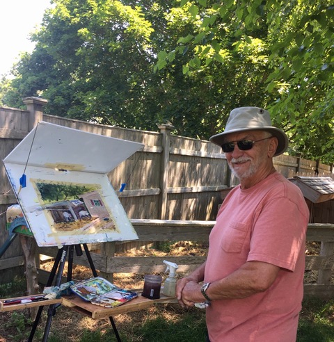 A man standing outside near a painting easel.