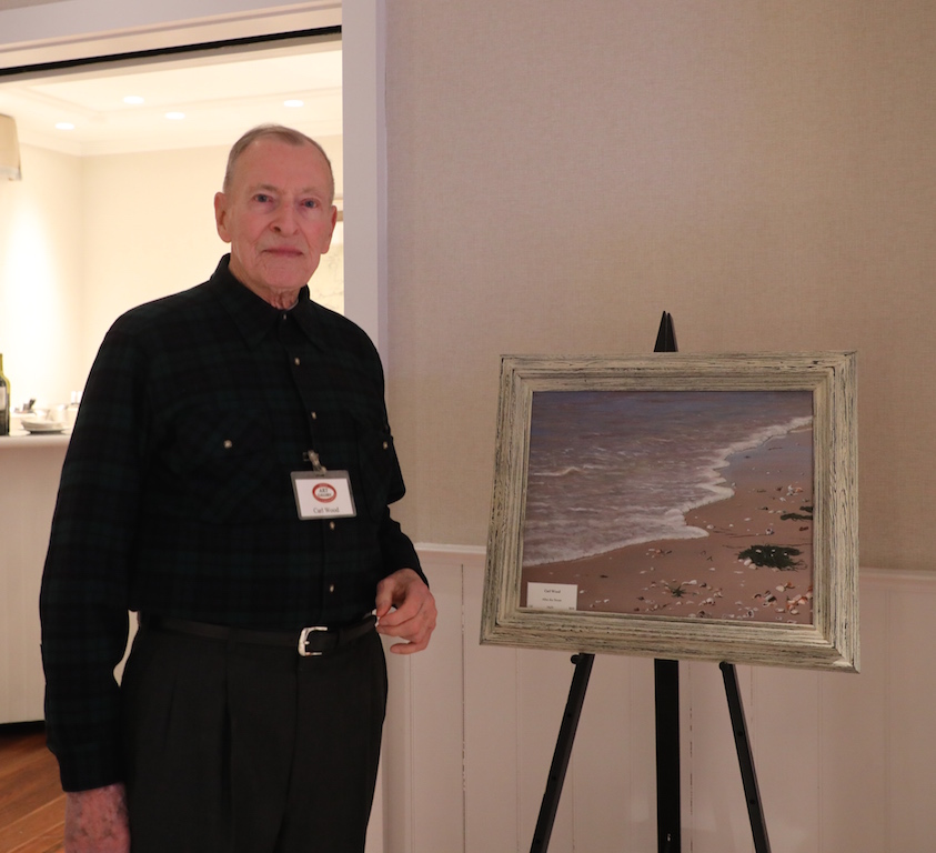 A man standing in front of a painting.