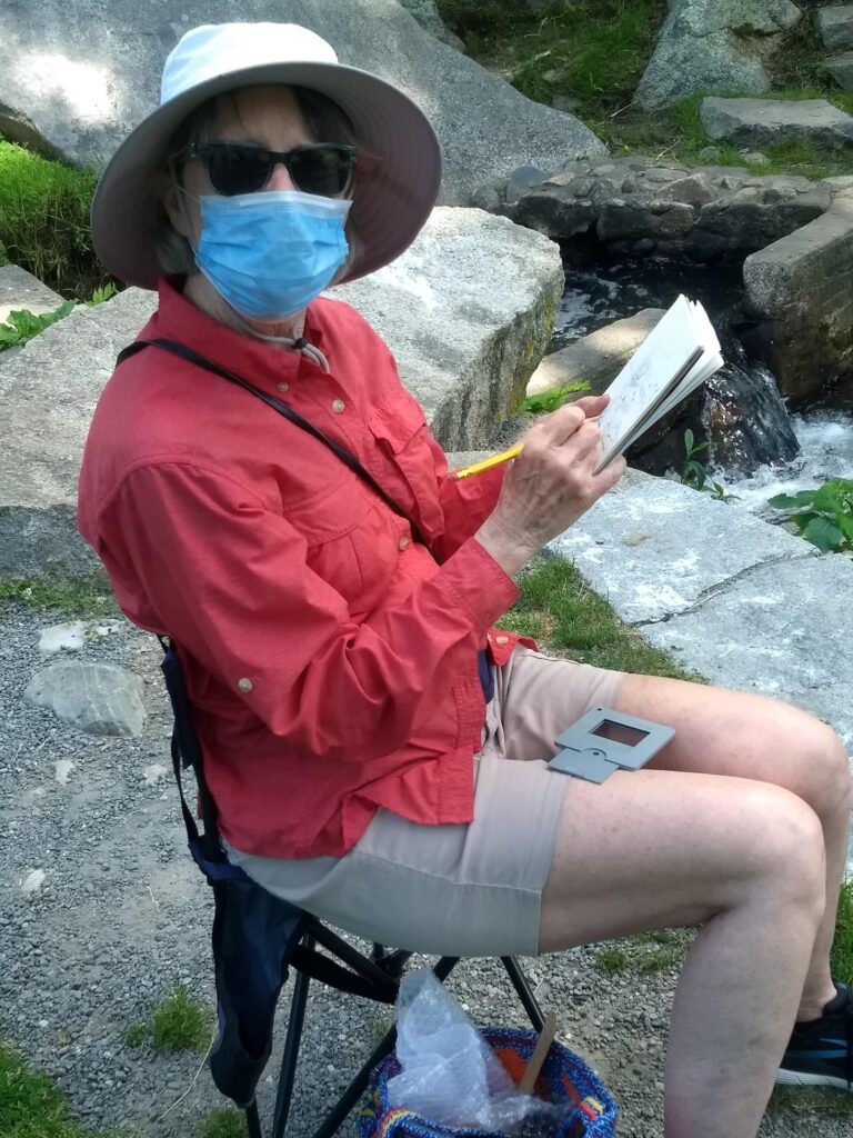 A woman wearing a face mask and sitting in a chair.