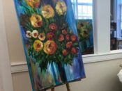 A painting of flowers on a easel.