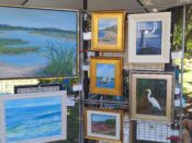 A display of paintings on display at an outdoor market.