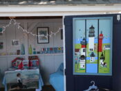A blue door with a lighthouse painted on it.