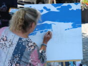 A woman painting on a huge canvass