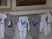 A group of baby clothes hanging on a clothesline.