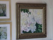 A framed painting of white peonies hanging on a wall.