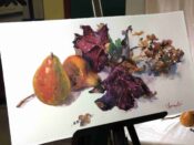 A watercolor painting of pears and leaves displayed on an easel, created by The Guild of Harwich Artists.