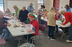 Guild members assemble miniature holiday ornaments sold to raise monies for local children's charities.